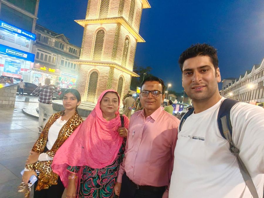 Visitors holding a Salma Tour And Travel Kashmir poster